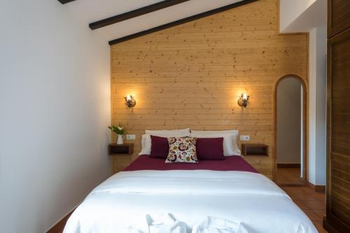 a large bed in a room with a wooden wall at Hotel Rural Casa Fontequeiroso in Muxia