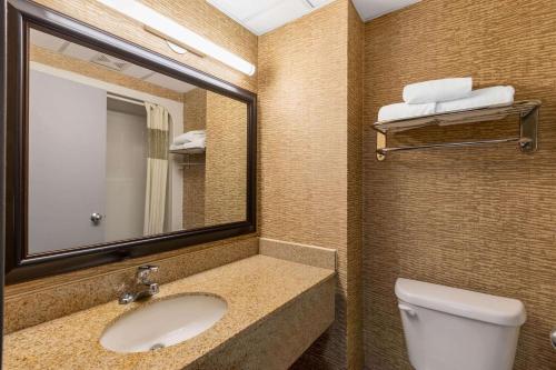 a bathroom with a sink and a mirror and a toilet at Howard Johnson by Wyndham Gillette in Gillette