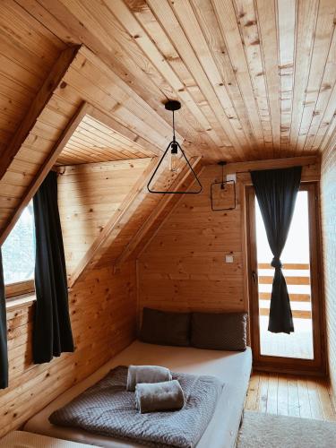 a bed in a room with a wooden ceiling at Casa Mia Resort in Kupres
