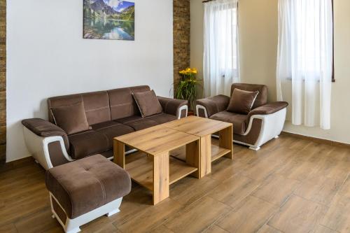 a living room with a couch and a table and chairs at Семеен хотел При Вергил in Sapareva Banya