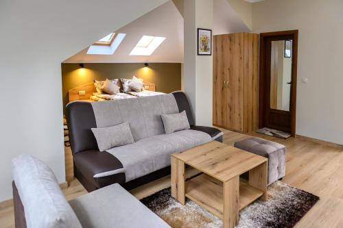 a living room with a couch and a bed at Семеен хотел При Вергил in Sapareva Banya