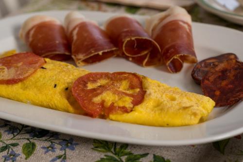 a plate of breakfast food with eggs and bacon at Hotel Rural Casa Fontequeiroso in Muxia
