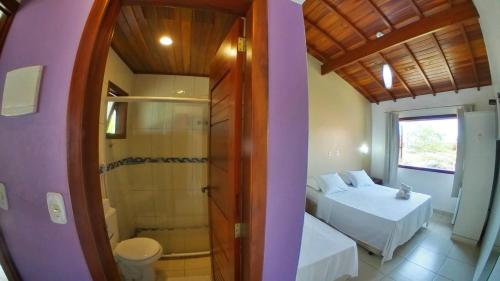 Pousada Villa Maritima في ترينيداد: غرفة نوم بسريرين وحمام مع دش