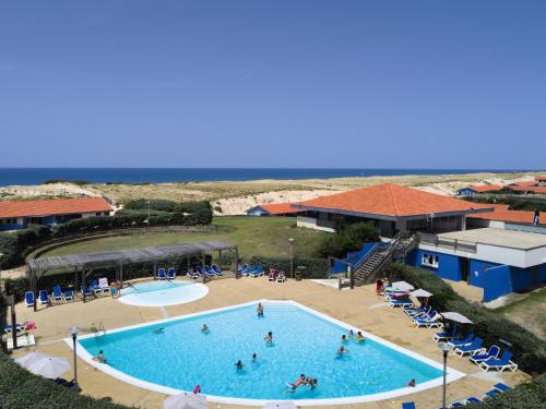 einen Blick über einen Pool mit Meerblick im Hintergrund in der Unterkunft Belambra Clubs Seignosse Les Estagnots in Seignosse