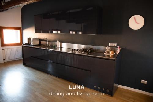 una cocina con armarios negros y una pared negra en Sole & Luna apartments, en Venecia