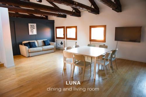 a dining room with a table and chairs and a couch at Sole & Luna apartments in Venice
