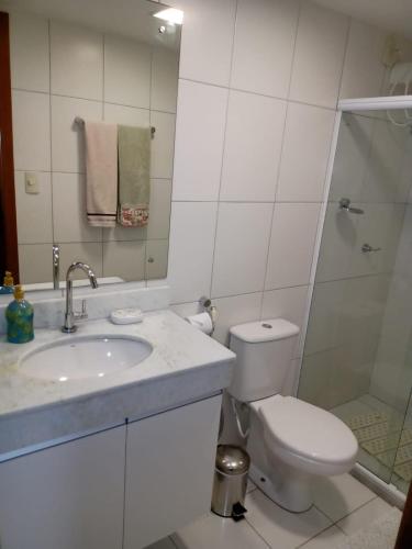 a bathroom with a toilet and a sink and a shower at Paraíso dos corais Pe na areia in Guarajuba