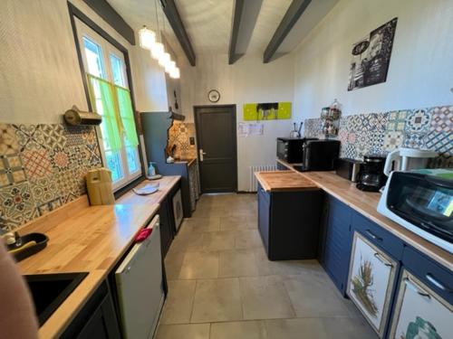 - une grande cuisine avec des comptoirs en bois dans l'établissement maison de charme, à Grézillac