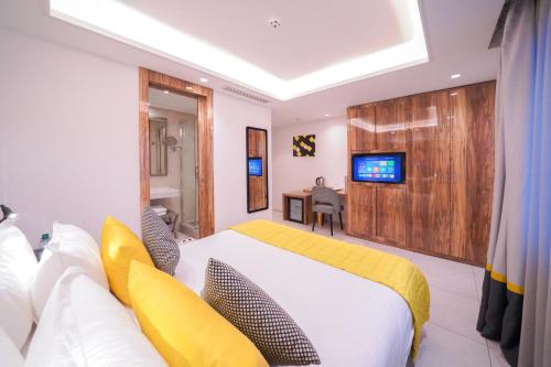 Cette chambre comprend un lit et une télévision murale. dans l'établissement Oum Palace Hotel & Spa, à Casablanca