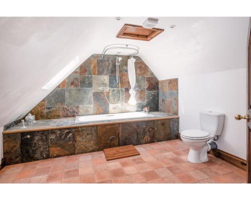 a bathroom with a toilet and a bath tub at Huish Lodge in Radstock