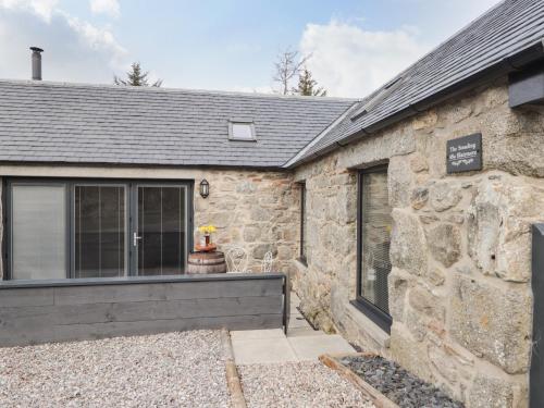 a stone building with a door and a window at The Steading in Rogart