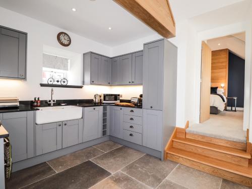 a kitchen with gray cabinets and a sink at The Steading in Rogart