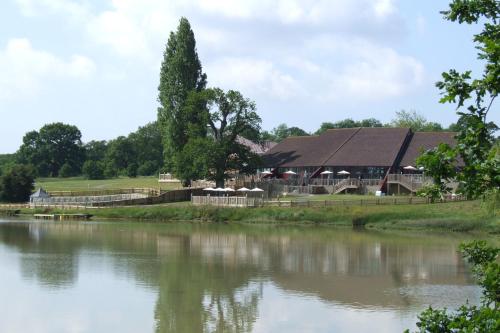 a barn next to a river with a building at Lakeside Park Hotel & Spa in Ryde
