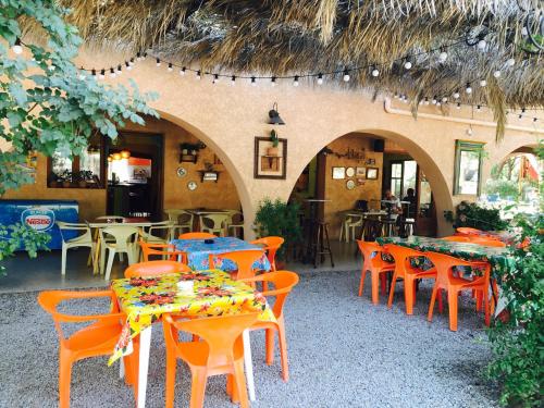 un restaurant avec des tables, des chaises, des tables et des chaises dans l'établissement Camping Paduella, à Calvi