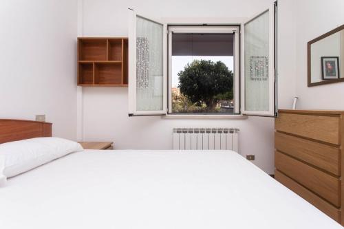 a bedroom with a white bed and a window at M278 - Marcelli, delizioso bilocale con terrazzo in Marcelli
