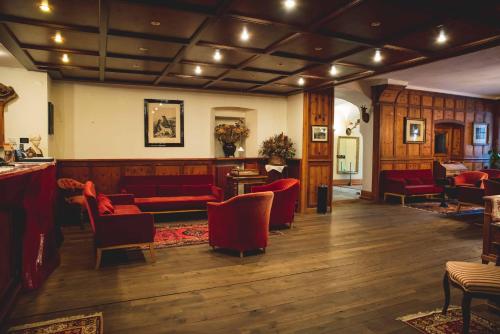 a lobby with red couches and chairs at Hotel La Villa della Regina in Gressoney-la-Trinité