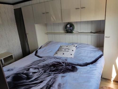 a bedroom with a bed with a painting on it at Tiny Beachhouse Belgium, Wenduine in Wenduine