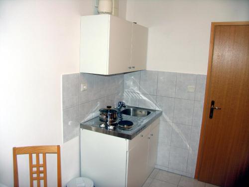 a small kitchen with a sink and a stove at Apartments Vidović in Vodice