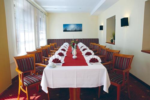 a conference room with a long table and chairs at AVALON Hotelpark Königshof in Königslutter am Elm