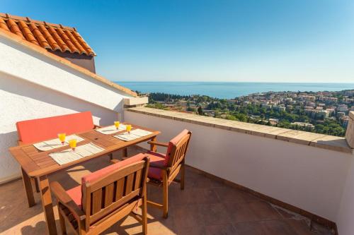 una mesa y sillas en un balcón con vistas en Apartment Sun & Sky, en Dubrovnik