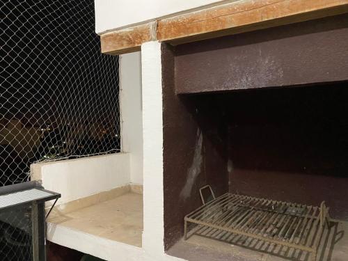 ein Gebäude mit einem Käfig mit einem Zaun in der Unterkunft Departamento de 2 dormitorios con asador in Santiago del Estero
