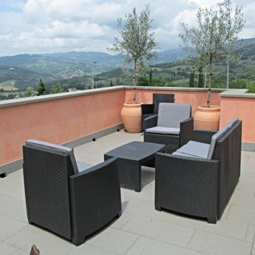 a patio with chairs and tables on a roof at Residence Fiesole in Fiesole
