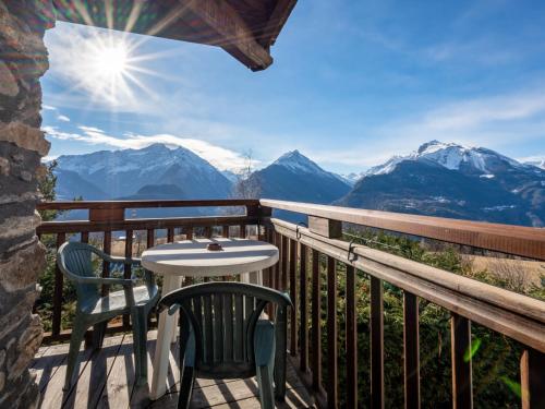 d'une table et de chaises sur un balcon avec vue sur les montagnes. dans l'établissement Apartment Grand Sarriod-3 by Interhome, à Saint-Nicolas
