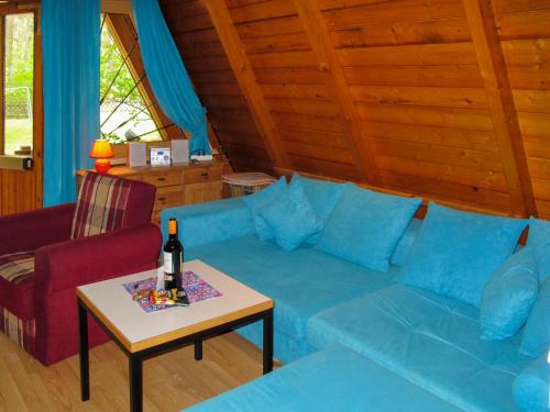 a living room with a blue couch and a table at Chalet Nepumuk-3 by Interhome in Arendsee