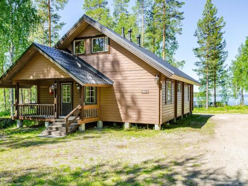 uma pequena cabana na floresta com um alpendre em Holiday Home Lakunlahti by Interhome em Paalasmaa
