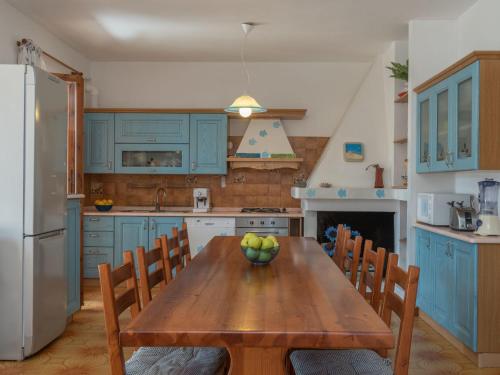 una cocina con una mesa de madera con un tazón de manzanas. en Apartment Casa Casu by Interhome, en Solanas