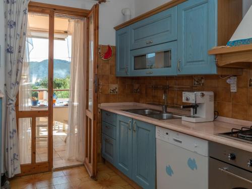 a kitchen with blue cabinets and a sink at Apartment Casa Casu by Interhome in Solanas