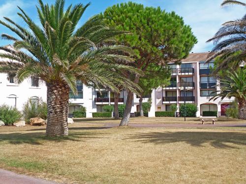 twee palmbomen voor een gebouw bij Apartment Antigua by Interhome in Le Barcarès