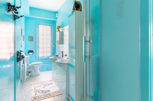 une salle de bain bleue avec des toilettes et un lavabo dans l'établissement Duplex Villa Georges, à Mers-les-Bains