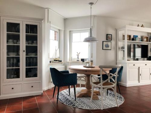 a dining room with a table and chairs at Holiday Home Sandmuschel by Interhome in Norddeich