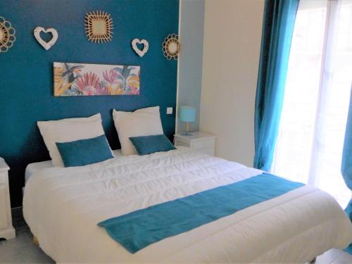 una camera da letto con un grande letto con pareti blu di Apartment Ô petit bonheur by Interhome a Houlgate