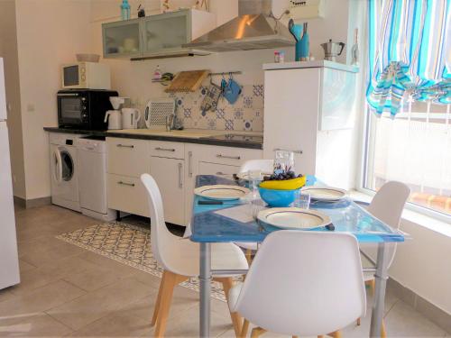 una cucina con tavolo blu e sedie bianche di Apartment Ô petit bonheur by Interhome a Houlgate