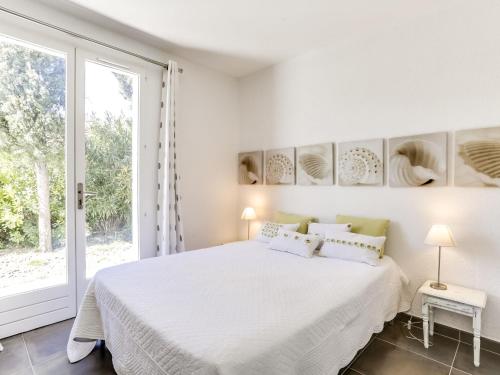 une chambre blanche avec un grand lit et une fenêtre dans l'établissement Holiday Home Les Vallons de la Gaillarde 1 by Interhome, à Saint-Aygulf