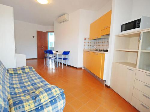 eine Küche und ein Wohnzimmer mit einem Sofa und einem Tisch in der Unterkunft Apartment Simma-8 by Interhome in Bibione