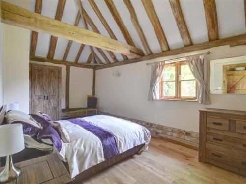 BenendenにあるHoliday Home Barley Byre by Interhomeの木製の天井が特徴のベッドルーム1室(ベッド1台付)