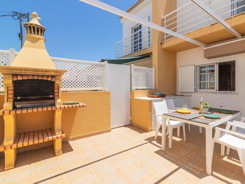 a patio with a fireplace and a table and chairs at Holiday Home Sunny Home by Interhome in Pêra