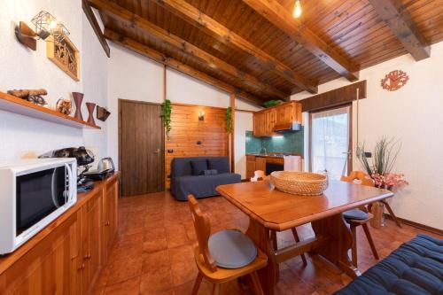 a kitchen and living room with a wooden table at ASIAGO - Chalet panoramico con Wifi e Free Parking in Gallio