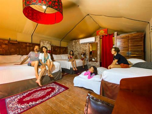 a woman sitting on a bed in a room at Serenity Authentic Glamping Tulum in Xpu Ha