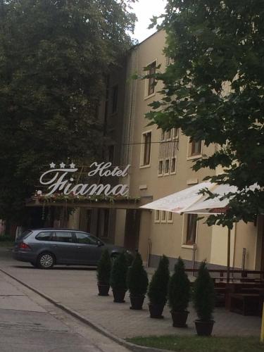 a building with a car parked in front of it at Hotel Fiama in Oţelu Roşu