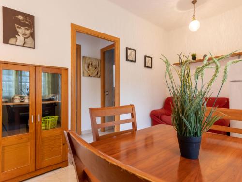 a dining room with a wooden table with a plant on it at Apartment Marie by Interhome in Torredembarra