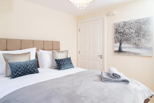 a bedroom with a large bed with blue pillows at 1 Eureka Mews in Chester-le-Street