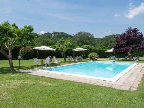 a swimming pool in a yard with chairs and umbrellas at Holiday Home Il Fienile del Casolare by Interhome in Penna
