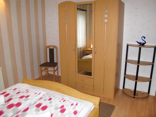 a bedroom with a cabinet and a bed and a chair at Holiday Home Siglinde by Interhome in Goldberg