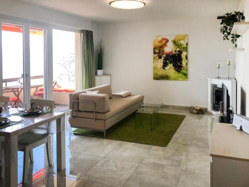 ein Wohnzimmer mit einem Sofa und einem Tisch in der Unterkunft Apartment Aldesago Monte Brè - Utoring-1 by Interhome in Aldesago