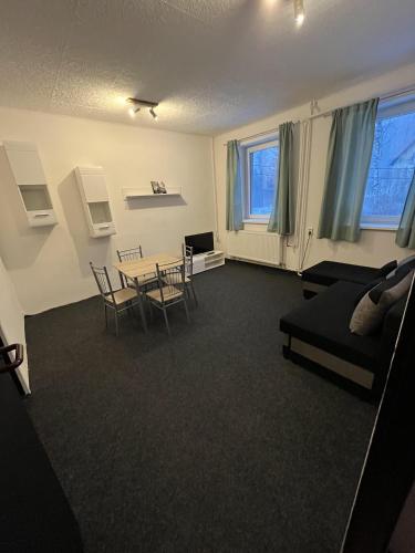 a living room with a table and chairs and a couch at Pension Martinské údolí - dependance in Kořenov