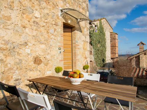 a wooden table with a bowl of fruit on a patio at Holiday Home Casa Francesca by Interhome in Rosia